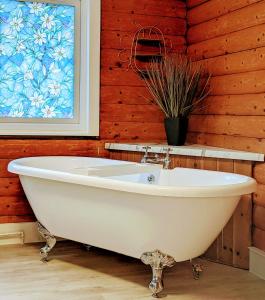 a white bath tub in a room with a window at Kaoglen Doe-Feature Bathroom-Cairngorms-Pets Allowed in Balnald
