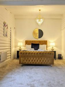 Un dormitorio con una cama grande y una lámpara de araña. en Kaoglen Doe-Feature Bathroom-Cairngorms-Pets Allowed, en Balnald
