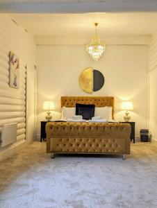 a bedroom with a large bed and a chandelier at Kaoglen Doe-Feature Bathroom-Cairngorms-Pets Allowed in Balnald