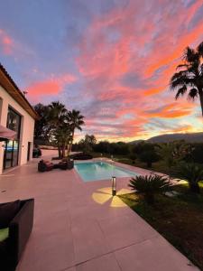 una puesta de sol sobre una piscina en una casa en Villa Blanche, en La Roquette-sur-Siagne
