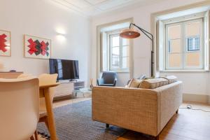 uma sala de estar com um sofá e uma televisão em Charming 2BDR Apartment in Lapa by LovelyStay em Lisboa