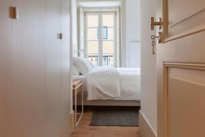 um quarto com uma cama e uma janela em Charming 2BDR Apartment in Lapa by LovelyStay em Lisboa