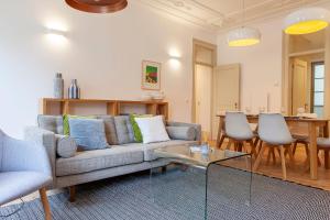 uma sala de estar com um sofá e uma mesa em Charming 2BDR Apartment in Lapa by LovelyStay em Lisboa