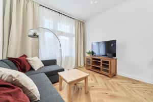 a living room with a couch and a tv at Family Apartment - 74m2 - Wapienna by Renters in Wrocław