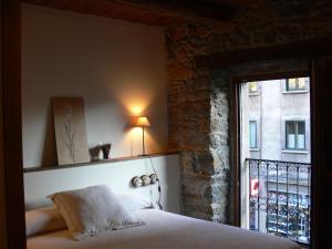 a bedroom with a bed next to a window at Hostal De Montaña La Aldeya in Villablino