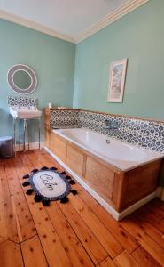 uma grande banheira num quarto com piso de madeira em Luxury 5-bed Villa - Winfields House em Prestonpans