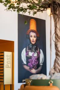 Una foto de una mujer con sombrero y flores. en Black F Tower - Serviced Apartments en Freiburg im Breisgau