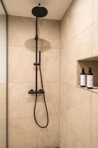 eine Dusche mit Duschkopf im Bad in der Unterkunft Black F Tower - Serviced Apartments in Freiburg im Breisgau