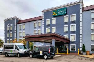 un hôtel avec deux véhicules garés devant lui dans l'établissement Quality Inn & Suites CVG Airport, à Erlanger