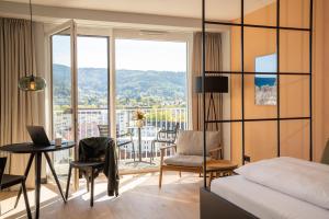 a bedroom with a bed and a table with a laptop at Black F Tower - Serviced Apartments in Freiburg im Breisgau