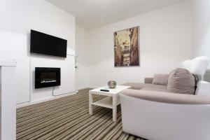 een witte woonkamer met een bank en een tv bij Brown house in Leeds in Leeds
