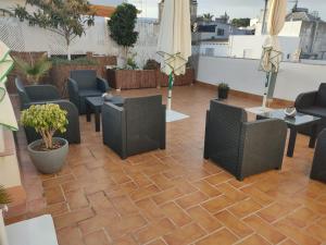 a patio with chairs and tables on a roof at Apartamento la Capillita in Sanlúcar de Barrameda