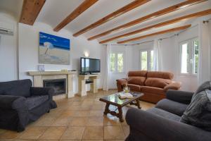 uma sala de estar com sofás, uma televisão e uma lareira em Anngo em Xàbia