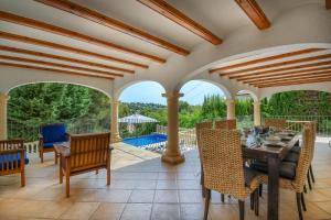 un patio con mesa, sillas y piscina en Anngo, en Jávea