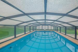 een binnenzwembad met een plafond en ramen bij Maison d'une chambre avec piscine partagee jardin clos et wifi a Villemur sur Tarn in Villemur-sur-Tarn