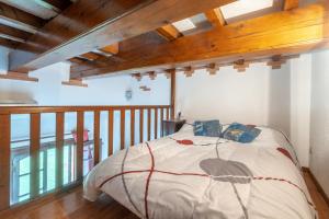 ein Schlafzimmer mit einem Bett in einem Zimmer mit Holzdecken in der Unterkunft Charmante maison à Villemur-sur-Tarn avec piscine partagée in Villemur-sur-Tarn