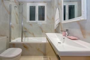 a bathroom with a sink and a toilet and a shower at The Bright Suite in Corfu