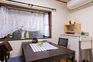 uma pequena cozinha com uma mesa e uma janela em Noriko's Home - Vacation STAY 8643 em Kawasaki