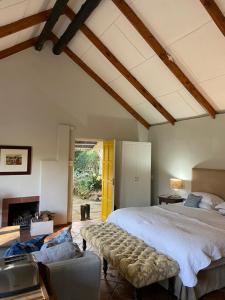 a bedroom with a large bed and a fireplace at Yellowwoods Farm - POOL COTTAGE (self-catering) in Curryʼs Post