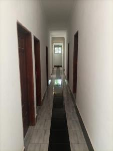 a long hallway with white walls and floors and a long corridor at Pearl Motel Buloba in Buloba