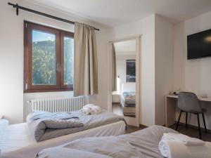 a bedroom with two beds with a teddy bear on top of it at Hotel Garnì Alta Valle in Ponte di Legno