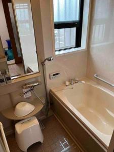 a bathroom with a tub and a toilet and a sink at 民宿　setouchi in Takamatsu