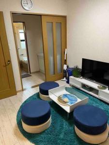高松市にある民宿　setouchiのリビングルーム(青いスツール2つ、テレビ付)