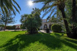 una casa con palmeras en el patio en Las Marinas 8, en Denia