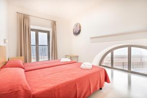 a bedroom with a large bed with an orange blanket at Albergue Inturjoven Chipiona in Chipiona +36 photos
