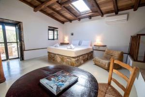 ein Schlafzimmer mit einem Bett, einem Stuhl und einem Tisch in der Unterkunft Αναμνήσεις - παραδοσιακό εξοχικό σπίτι με μεγάλο κήπο in Galaxidi