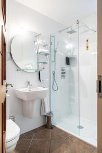 a bathroom with a glass shower and a sink at THE INN Hotel Bar and Restaurant in Saint Helier Jersey