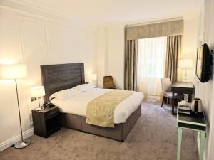 Pokój hotelowy z dużym łóżkiem i biurkiem w obiekcie Astor Court Hotel w Londynie