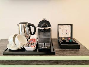 ein Tablett mit einer Kaffeemaschine und einer Uhr auf dem Tisch in der Unterkunft Astor Court Hotel in London