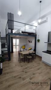 Habitación con mesa de comedor y cama elevada. en WISH SUITE MARIA AUXILIADORA DE SEVILLA, en Sevilla