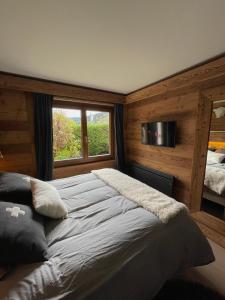 Un dormitorio con una cama grande y una ventana en CHALET MONT BLANC, en Combloux