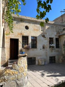 a stone building with a door and a stone wall at Kayhan Cave Villa in Ürgüp