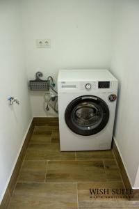 - Lavadora y secadora en una habitación pequeña en WISH SUITE MARIA AUXILIADORA DE SEVILLA, en Sevilla