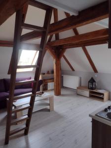 una sala de estar con techos de madera y una escalera en Pension Novy Den en Albrechtice