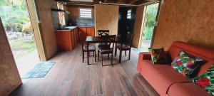 un soggiorno con un divano rosso e un tavolo di Maison Le Bois Joli Coeur a Saint-Benoît