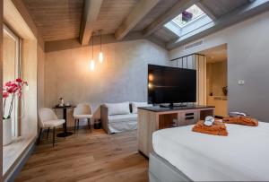 um quarto de hotel com uma cama e uma televisão em La Locanda di Petriolo em Monticiano
