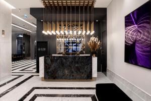 a lobby with a reception desk and a painting on the wall at Wish More Hotel Şişli in Istanbul