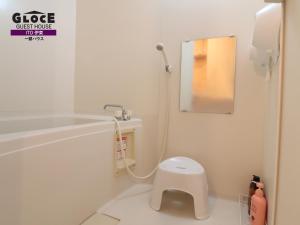 a white bathroom with a toilet and a mirror at GLOCE伊東一碧house 自然が溢れ閑静なエリアにあるログハウスを貸切り in Ito