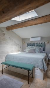 a bedroom with a large bed and a green bench at Duplex calme et climatisé au Centre historique in Avignon