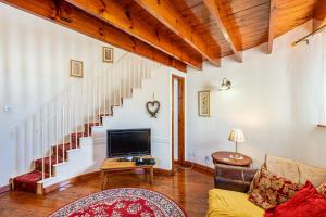 a living room with a tv and a staircase at Cider Tower in Kirkcudbright