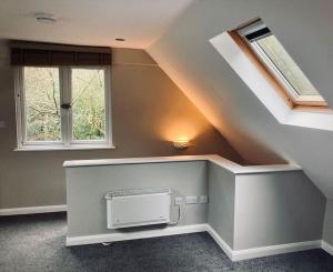 a room with a staircase with a window and a appliance at Owl Tree Cottage with access to Alice Holt in Farnham