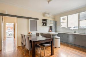 a kitchen and dining room with a table and chairs at Wollongong station holiday house with Wi-Fi,75 Inch TV, Netflix,Parking,Beach in Wollongong