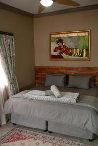 1 cama en un dormitorio con una foto en la pared en Casa de la Presa 4, en Polokwane