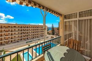 a balcony with a table and a view of a building at Tenerifeopenhome bright penthouse on the beach Los Cristianos in Arona