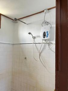 a shower in a tiled bathroom with a soap dispenser at Lavender Homestay Desa Chendering 3 bedrooms Kuala Terengganu in Kuala Terengganu