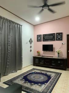 a living room with a ceiling fan and a rug at Lavender Homestay Desa Chendering 3 bedrooms Kuala Terengganu in Kuala Terengganu +5 photos